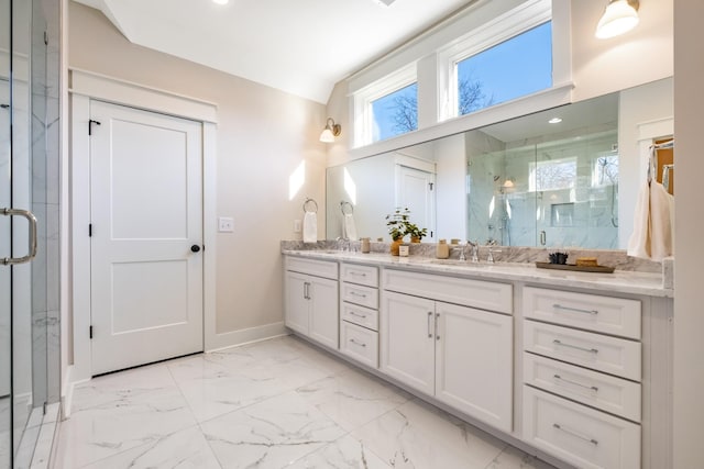 bathroom featuring a marble finish shower, baseboards, double vanity, marble finish floor, and a sink