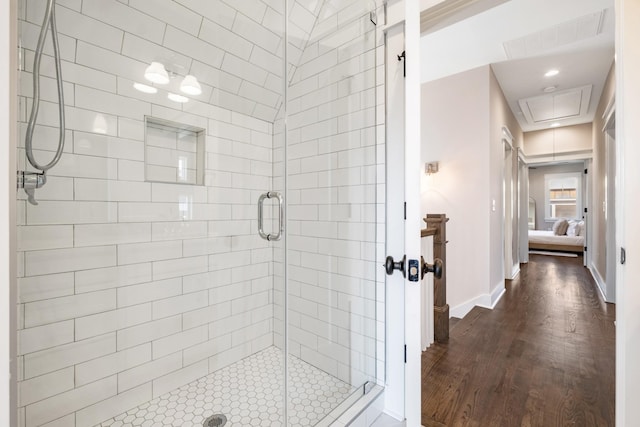 ensuite bathroom featuring visible vents, ensuite bathroom, wood finished floors, a shower stall, and baseboards