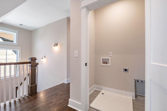 corridor featuring an upstairs landing, visible vents, baseboards, and wood finished floors