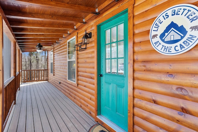 view of exterior entry with a porch and faux log siding