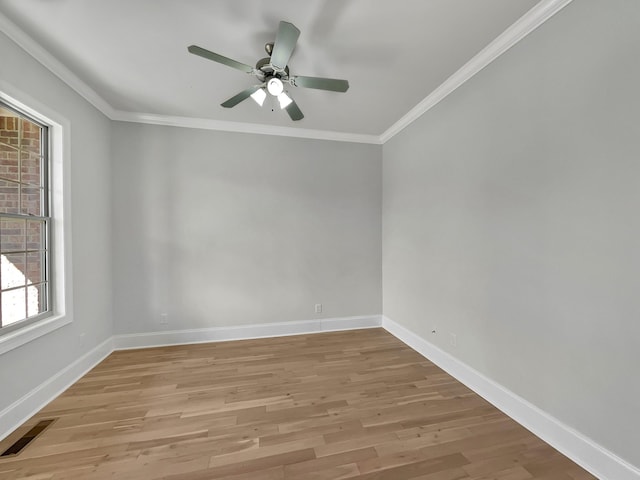 spare room featuring light wood-style floors, visible vents, and ornamental molding