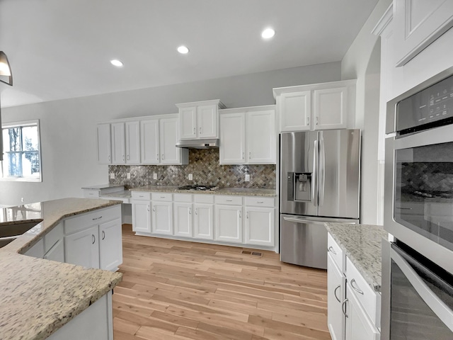 kitchen featuring tasteful backsplash, appliances with stainless steel finishes, white cabinets, and light wood finished floors