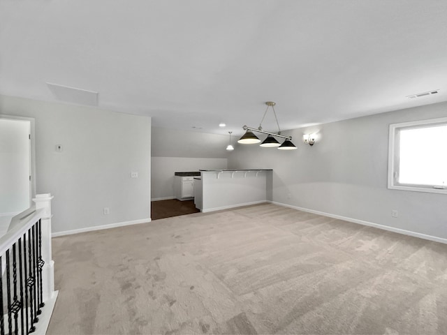 interior space with visible vents, light colored carpet, and baseboards