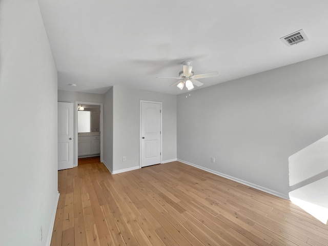 unfurnished bedroom with light wood finished floors, visible vents, a ceiling fan, and baseboards