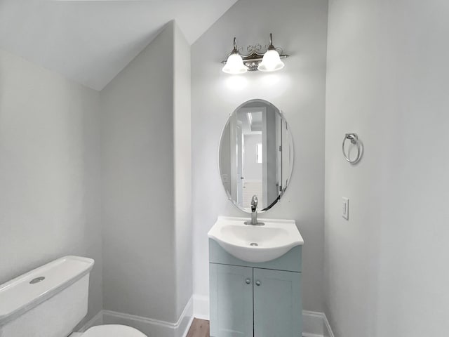 bathroom featuring baseboards, toilet, and vanity