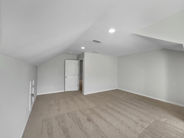 additional living space with visible vents, lofted ceiling, carpet floors, and baseboards