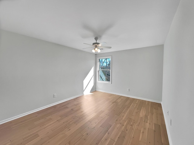 empty room featuring baseboards, light wood finished floors, and ceiling fan