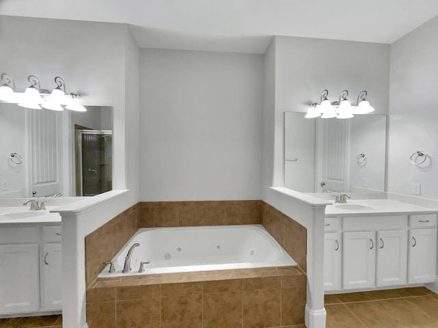 bathroom with tile patterned floors, a whirlpool tub, a stall shower, and a sink