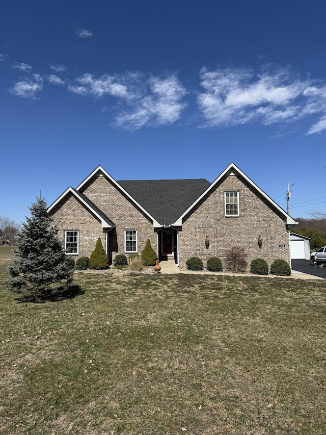 view of front of home with a garage, brick siding, and a front yard