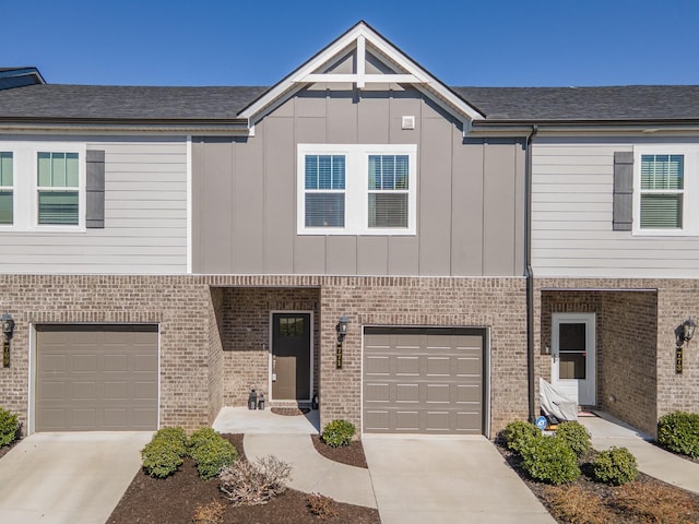 townhome / multi-family property featuring a garage, brick siding, board and batten siding, and concrete driveway