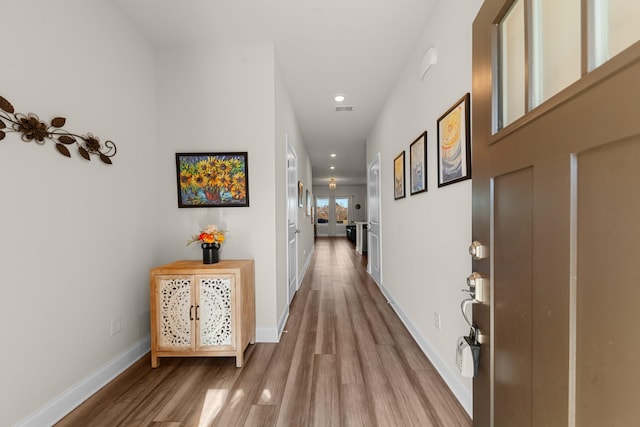 hall with recessed lighting, wood finished floors, visible vents, and baseboards