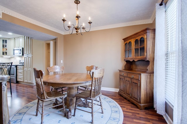 dining space with baseboards, an inviting chandelier, dark wood-style floors, and ornamental molding