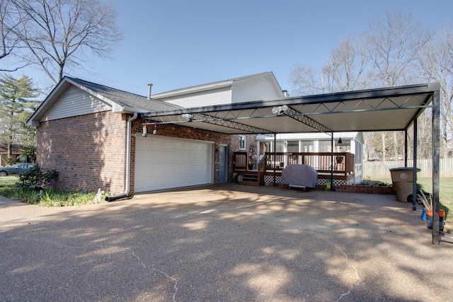 view of side of home featuring a garage, a carport, brick siding, and fence