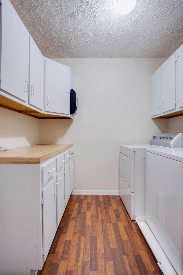 clothes washing area with baseboards, dark wood-style floors, cabinet space, a textured ceiling, and separate washer and dryer