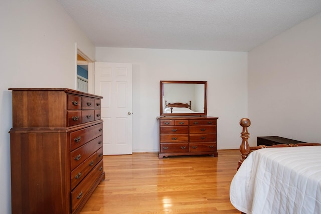 bedroom with light wood finished floors and a textured ceiling