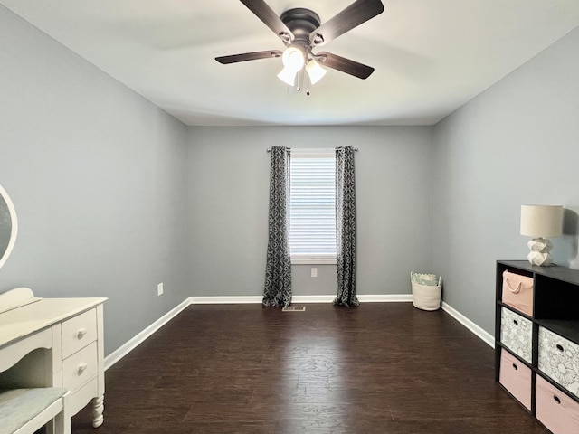 unfurnished bedroom with a ceiling fan, dark wood-type flooring, and baseboards