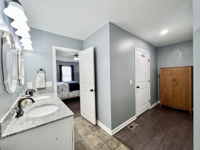 full bath with a sink, visible vents, baseboards, and ensuite bath