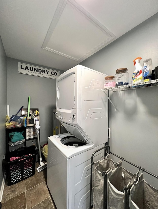 clothes washing area featuring laundry area and stacked washing maching and dryer