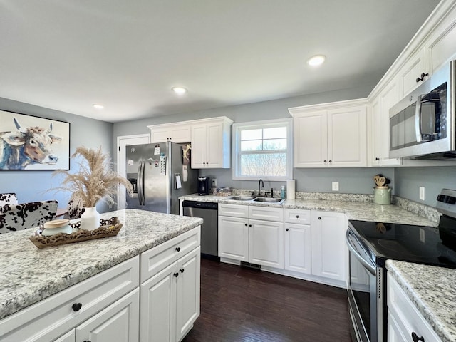 kitchen featuring dark wood-style flooring, appliances with stainless steel finishes, white cabinetry, and a sink