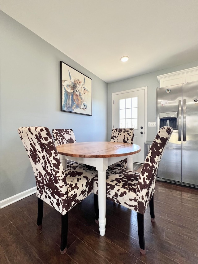 dining area featuring dark wood-style floors, breakfast area, and baseboards