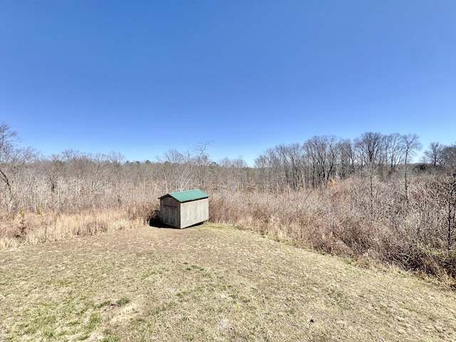 view of yard featuring an outbuilding, a storage shed, and a rural view