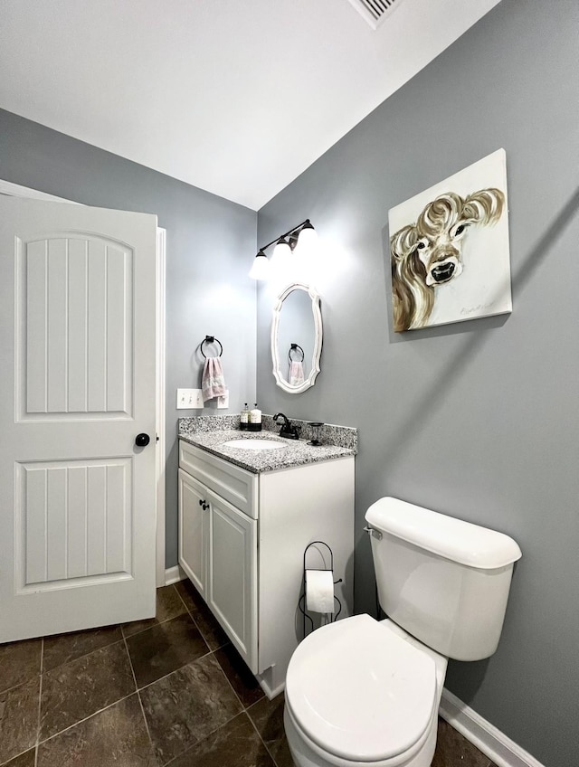 half bath featuring baseboards, toilet, and vanity