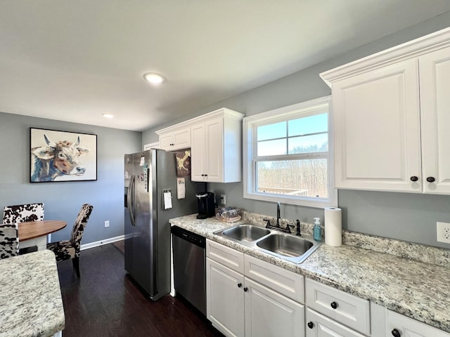 kitchen featuring white cabinetry, dark wood-type flooring, appliances with stainless steel finishes, and a sink