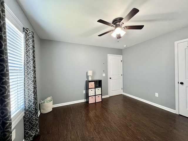 unfurnished bedroom featuring wood finished floors, baseboards, and ceiling fan