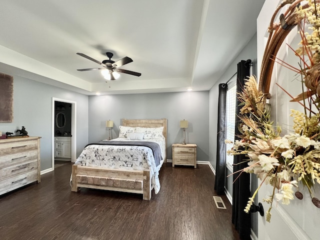 bedroom featuring dark wood finished floors, ceiling fan, a raised ceiling, and baseboards