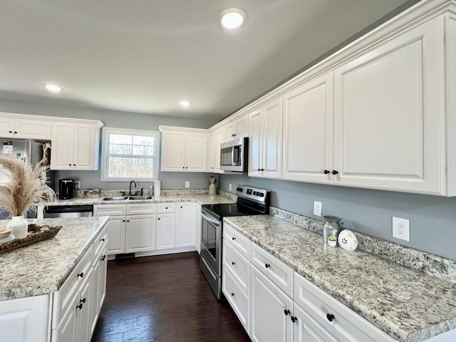 kitchen featuring recessed lighting, appliances with stainless steel finishes, white cabinetry, and a sink