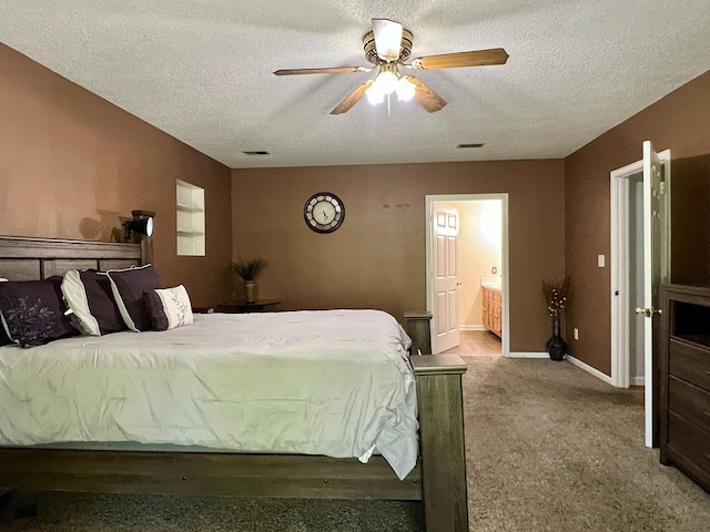 bedroom with carpet flooring, a textured ceiling, baseboards, visible vents, and connected bathroom