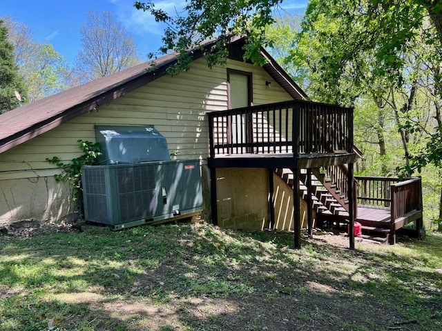 rear view of property featuring stairs and a deck