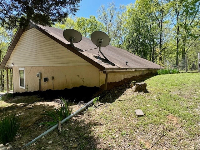 view of side of home with a yard