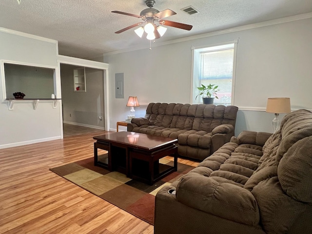 living area with a ceiling fan, visible vents, and crown molding