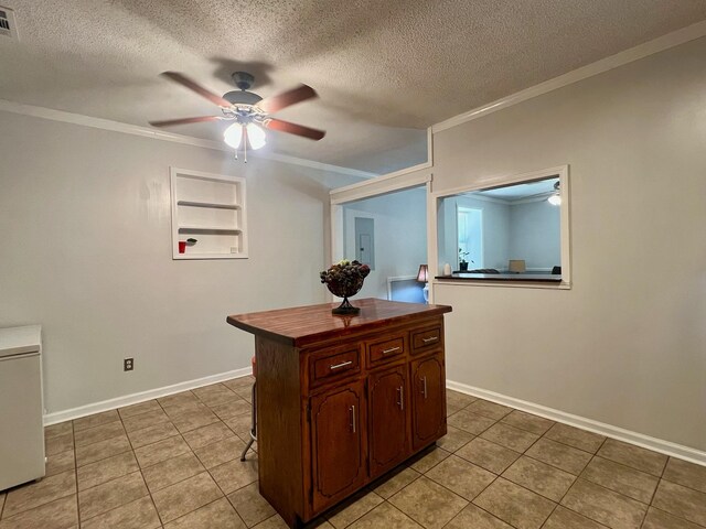 kitchen with a ceiling fan, a textured ceiling, butcher block countertops, and ornamental molding