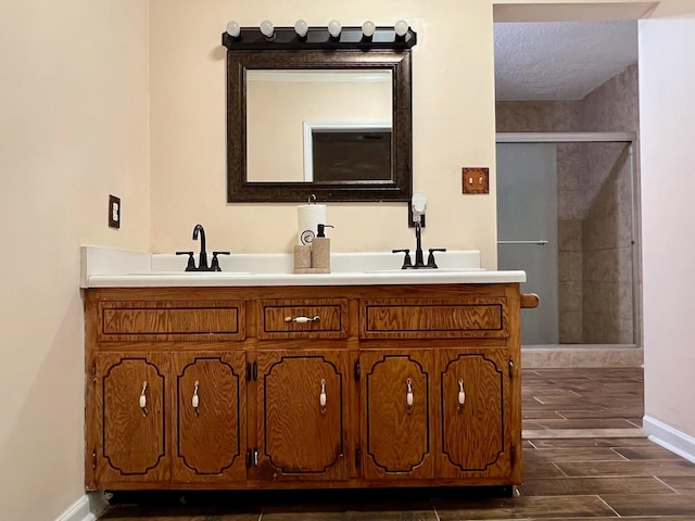 full bathroom with a shower stall, baseboards, vanity, and wood finished floors