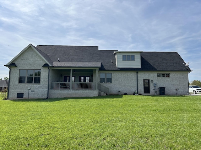 back of house with a yard, covered porch, a shingled roof, crawl space, and brick siding