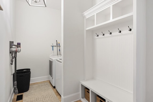 mudroom featuring baseboards and washing machine and clothes dryer