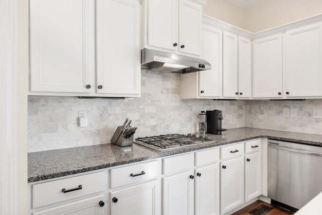 kitchen with under cabinet range hood, decorative backsplash, appliances with stainless steel finishes, and white cabinetry