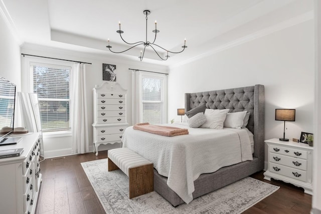 bedroom featuring ornamental molding, a tray ceiling, dark wood-style floors, baseboards, and a chandelier