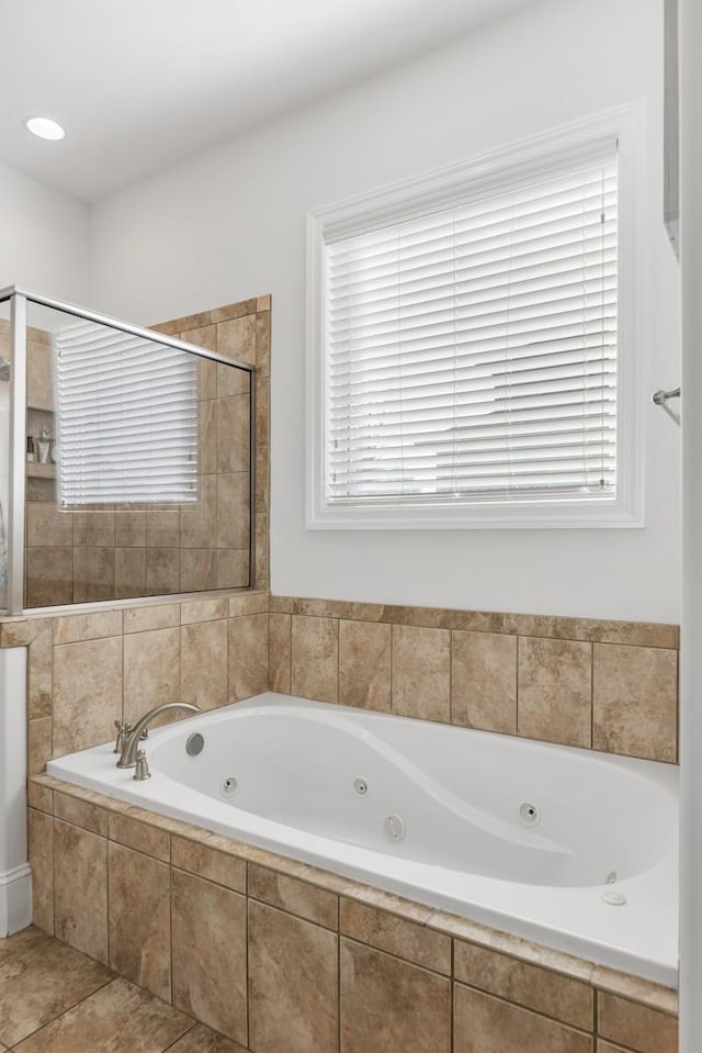 bathroom featuring tiled shower, plenty of natural light, and a jetted tub