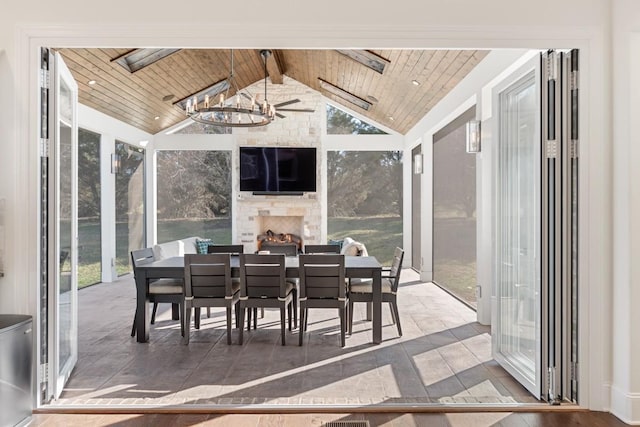 sunroom featuring a notable chandelier, wood ceiling, vaulted ceiling with beams, and a large fireplace