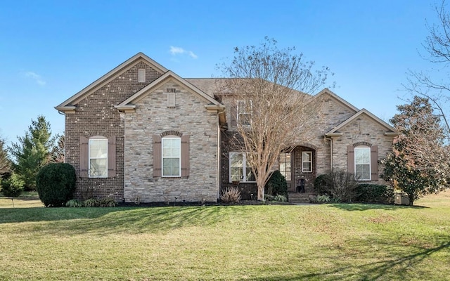 view of front of home with a front yard and brick siding