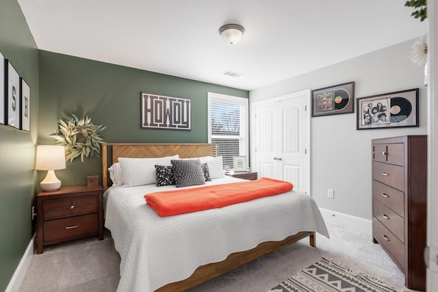 bedroom with visible vents, baseboards, carpet, and a closet