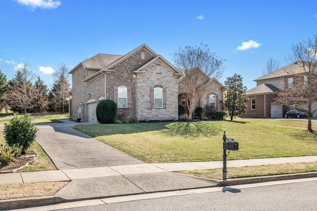 view of front facade with a front yard, an attached garage, brick siding, and driveway