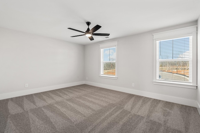 carpeted empty room featuring visible vents, a ceiling fan, and baseboards