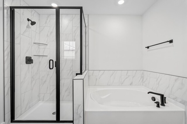 bathroom featuring a stall shower and a garden tub