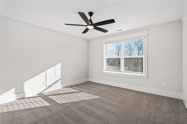 carpeted empty room featuring visible vents, a ceiling fan, and baseboards