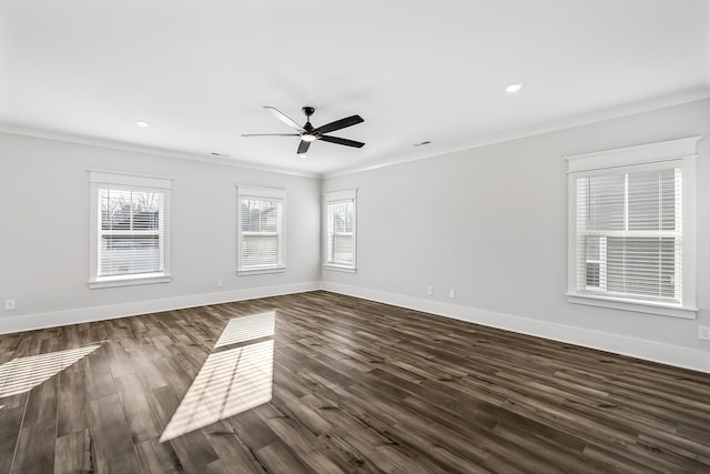 empty room featuring crown molding, dark wood-type flooring, and baseboards