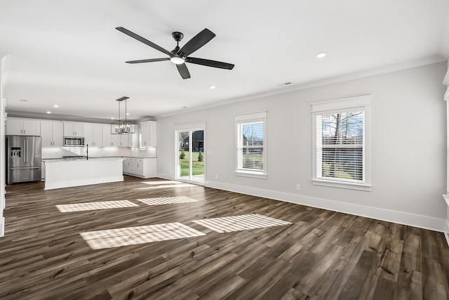 unfurnished living room featuring dark wood-style flooring, baseboards, and ornamental molding